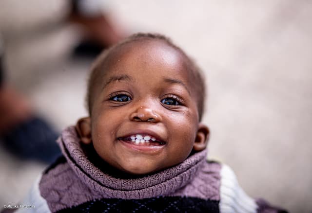 A smiling child at a YEE community gathering